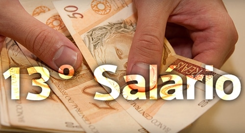 Mãos segurando notas de reais com o texto “13º Salário” sobreposto, representando o pagamento do décimo terceiro salário.