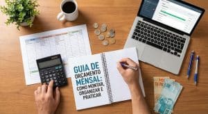 Pessoa organizando finanças pessoais, mostrando como montar um orçamento mensal em um caderno com o título ‘Guia de Orçamento Mensal’, usando calculadora, notebook com planilha financeira, moedas e cédulas de real sobre uma mesa de madeira