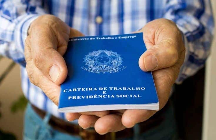 Mãos segurando a carteira de trabalho brasileira, símbolo do emprego formal e dos impactos do desemprego no Brasil na vida dos trabalhadores.