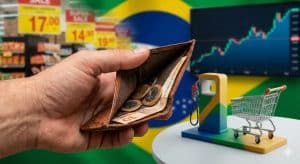 Mão segurando carteira com poucas moedas e notas, diante de cenário com supermercado, carrinho de compras, bomba de combustível e gráfico em alta, ilustrando a inflação no Brasil causas e consequências no bolso do consumidor.